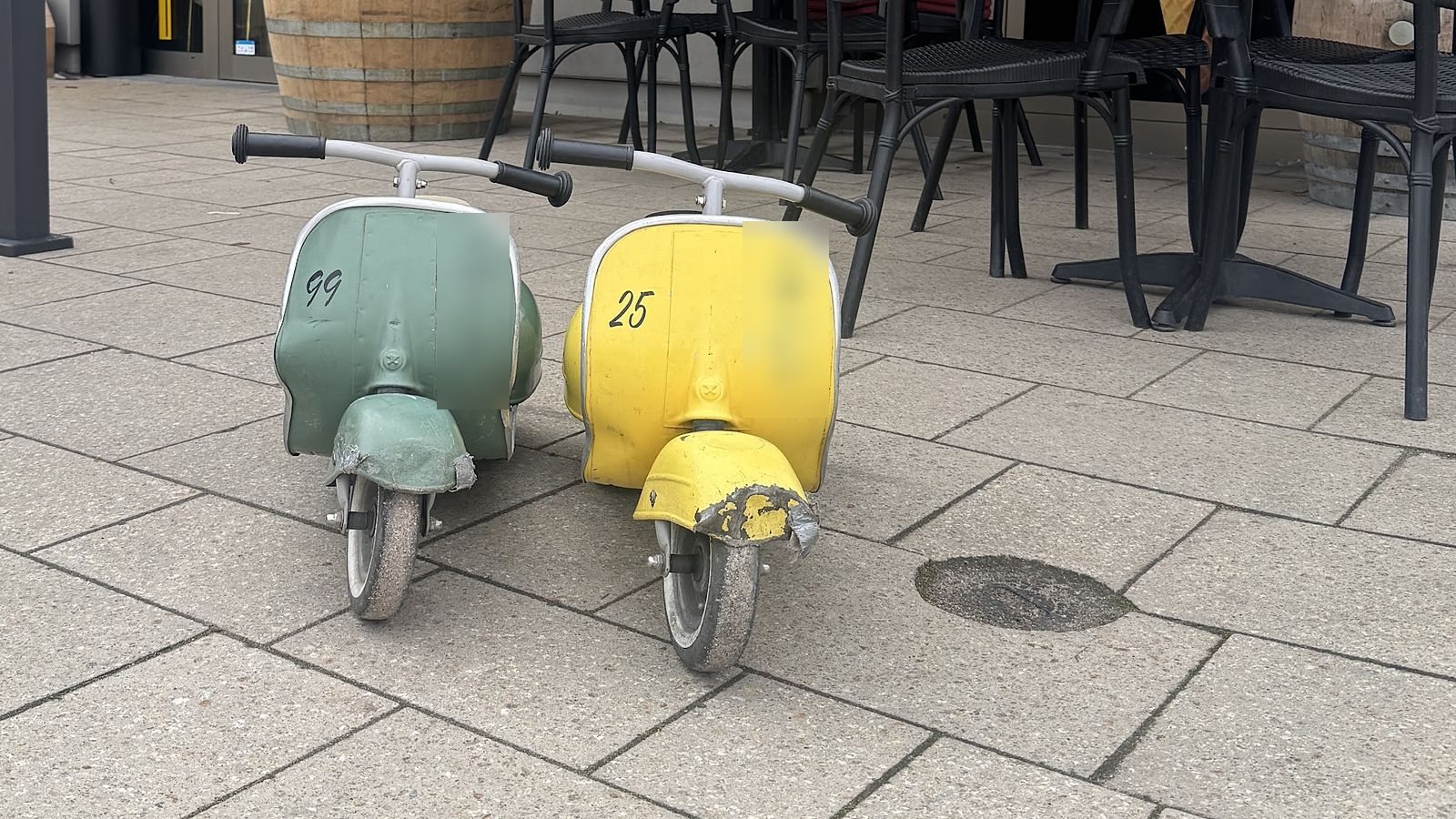 Zwei kleine Vespas in Mint und Gelb vor dem Eingang