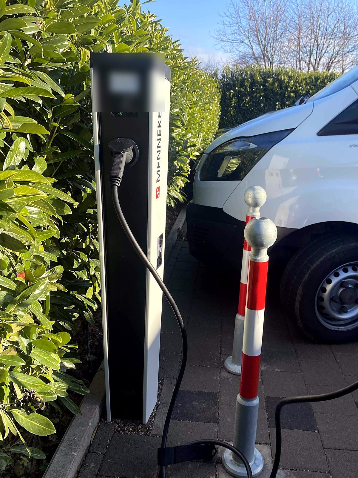Ladesäule auf dem Betriebshof mit angeschlossenem Fahrzeug