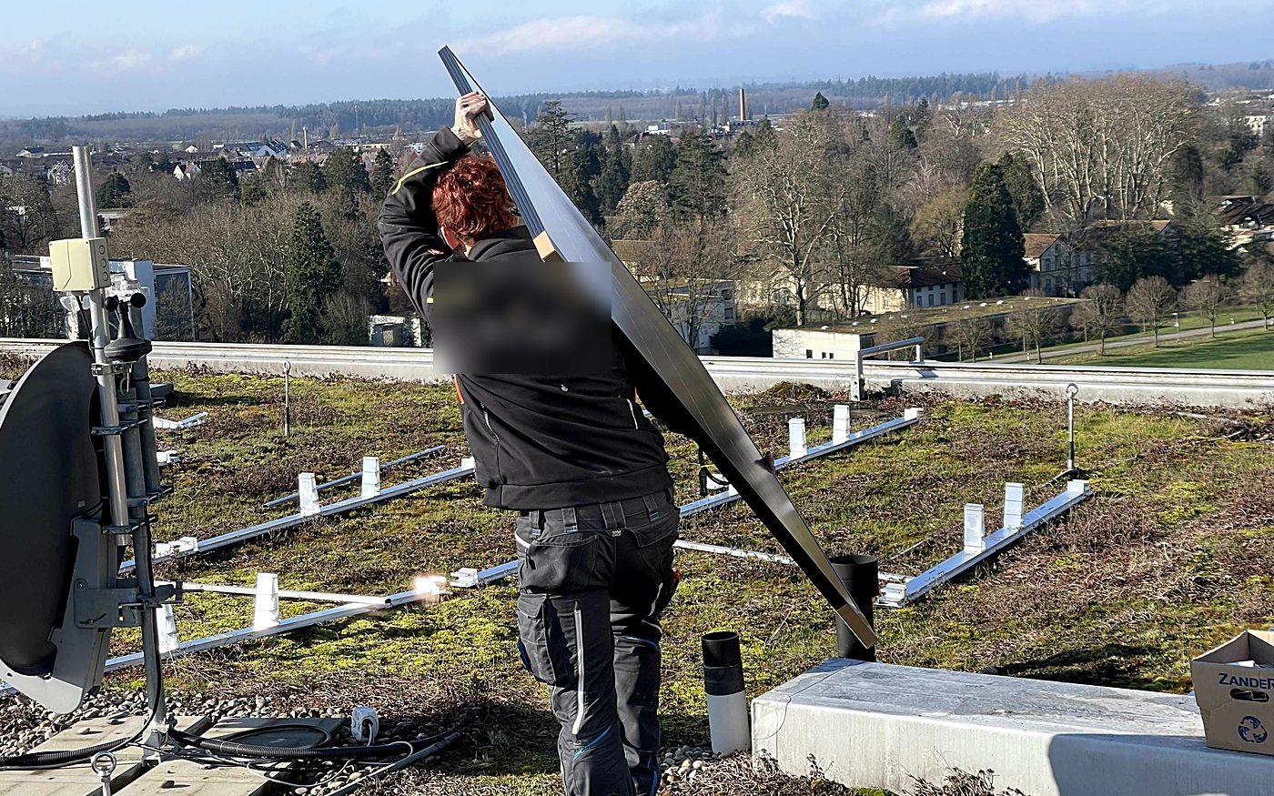 Monteur montiert eine Antenne auf einem Flachdach