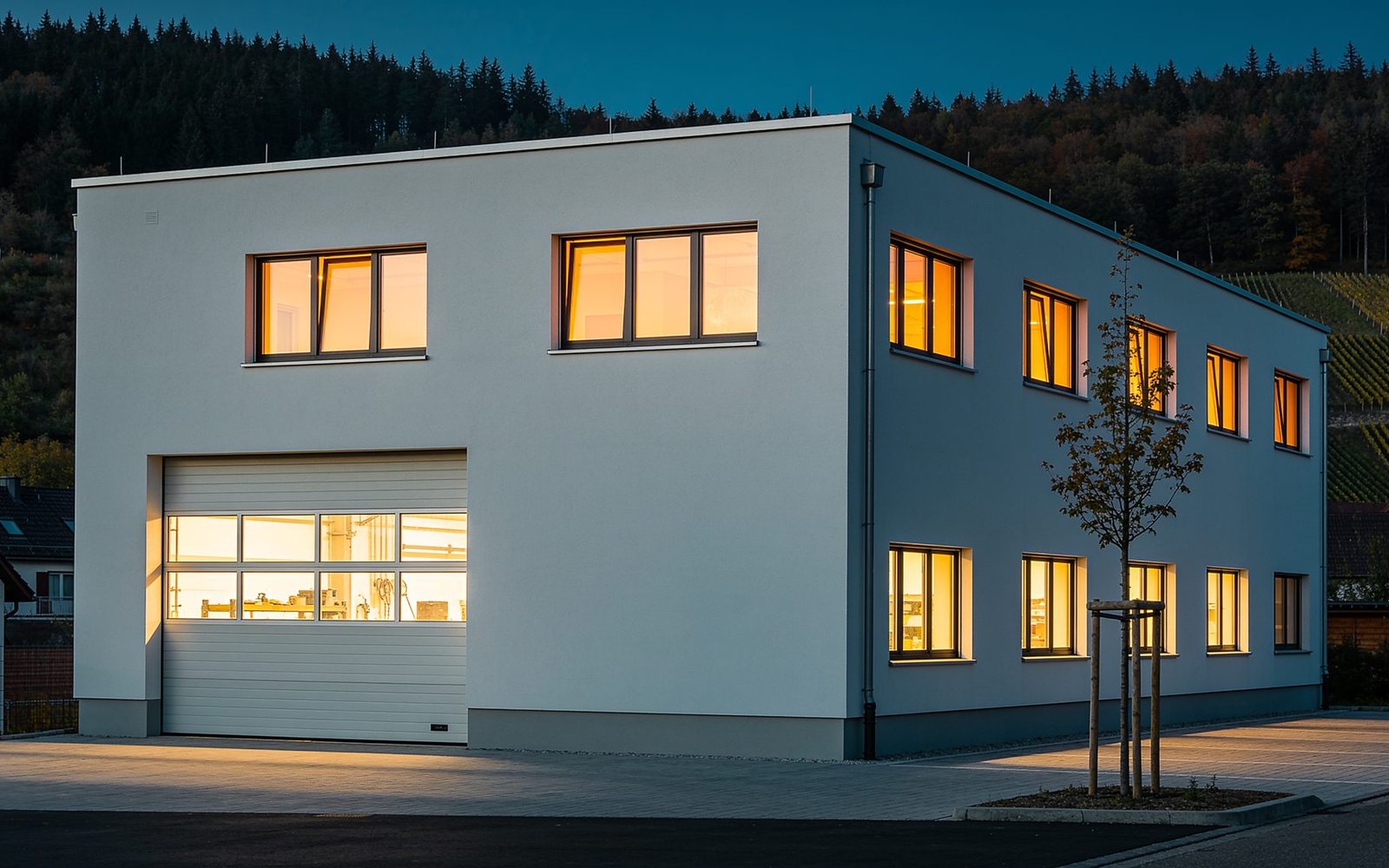 Die Mannschaft von Elektro Mustermann vor Anhänger und Firmenwagen am Betrieb in Musterdorf