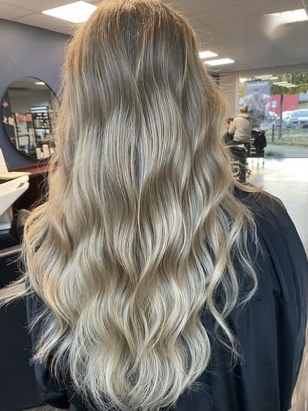 Lange, sanft gewellte Haare in Beigeblond, von hinten fotografiert