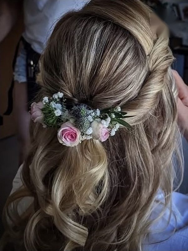 Halboffene Brautfrisur mit Rosen und kleinen Blüten im Haar