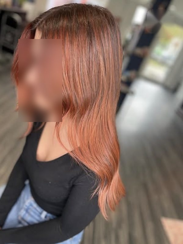 Lange Haare in Kupferrot, seitlich über die Schulter fallend