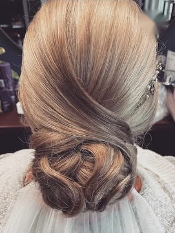 Tief gesteckter Knoten mit seitlich gelegter Welle und Haarschmuck